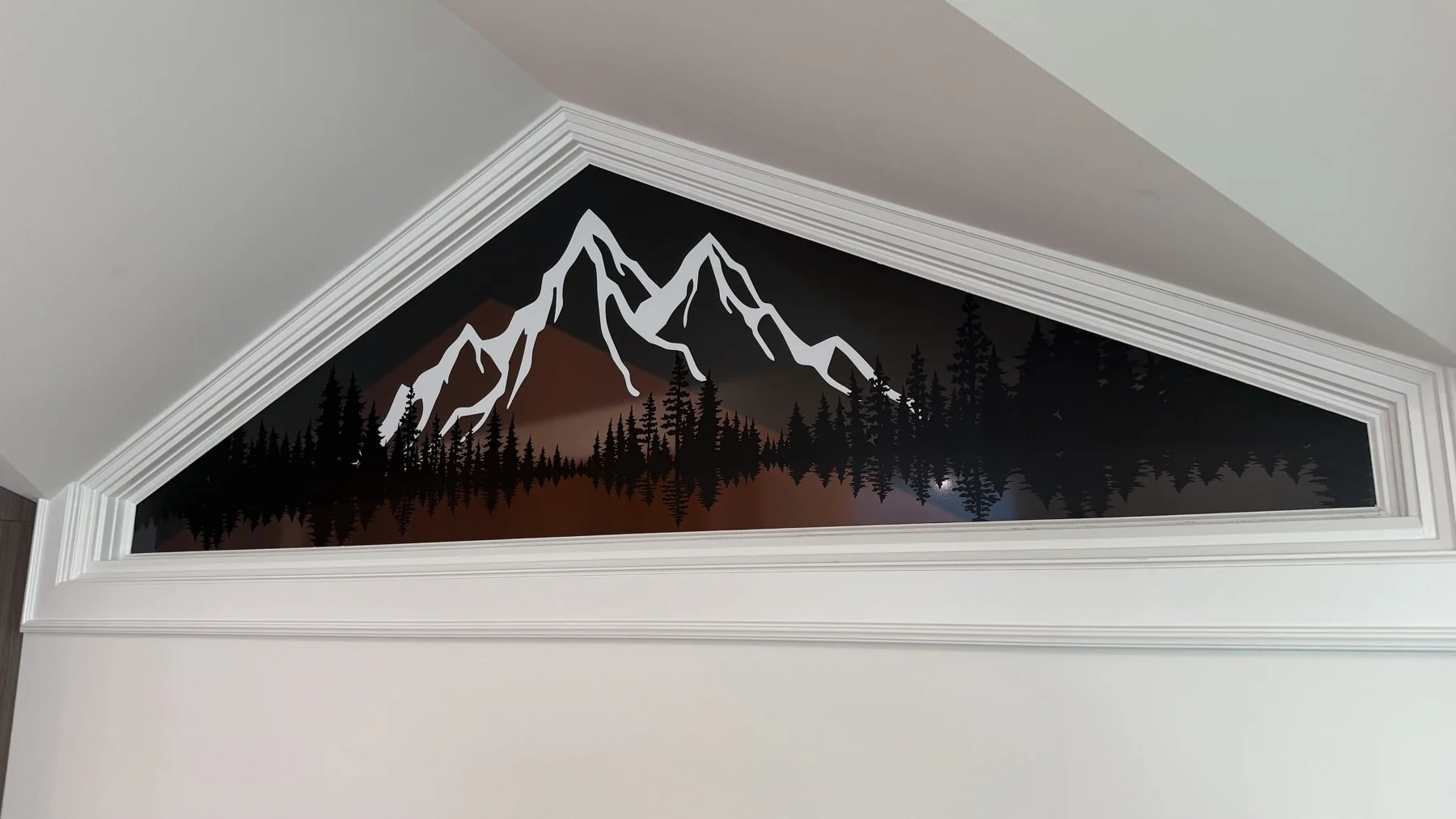 Mountain silhouette graphic installed in a peaked residential window